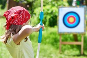 Girl aiming bow at archery target